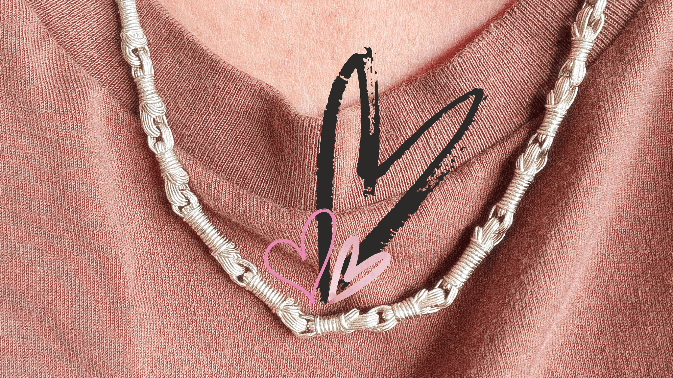 Tallisman I Necklace №2 · Sterling Silver Brown T-shirt neckline of woman with graphic art hearts above the necklace in light and medium pink and black pink