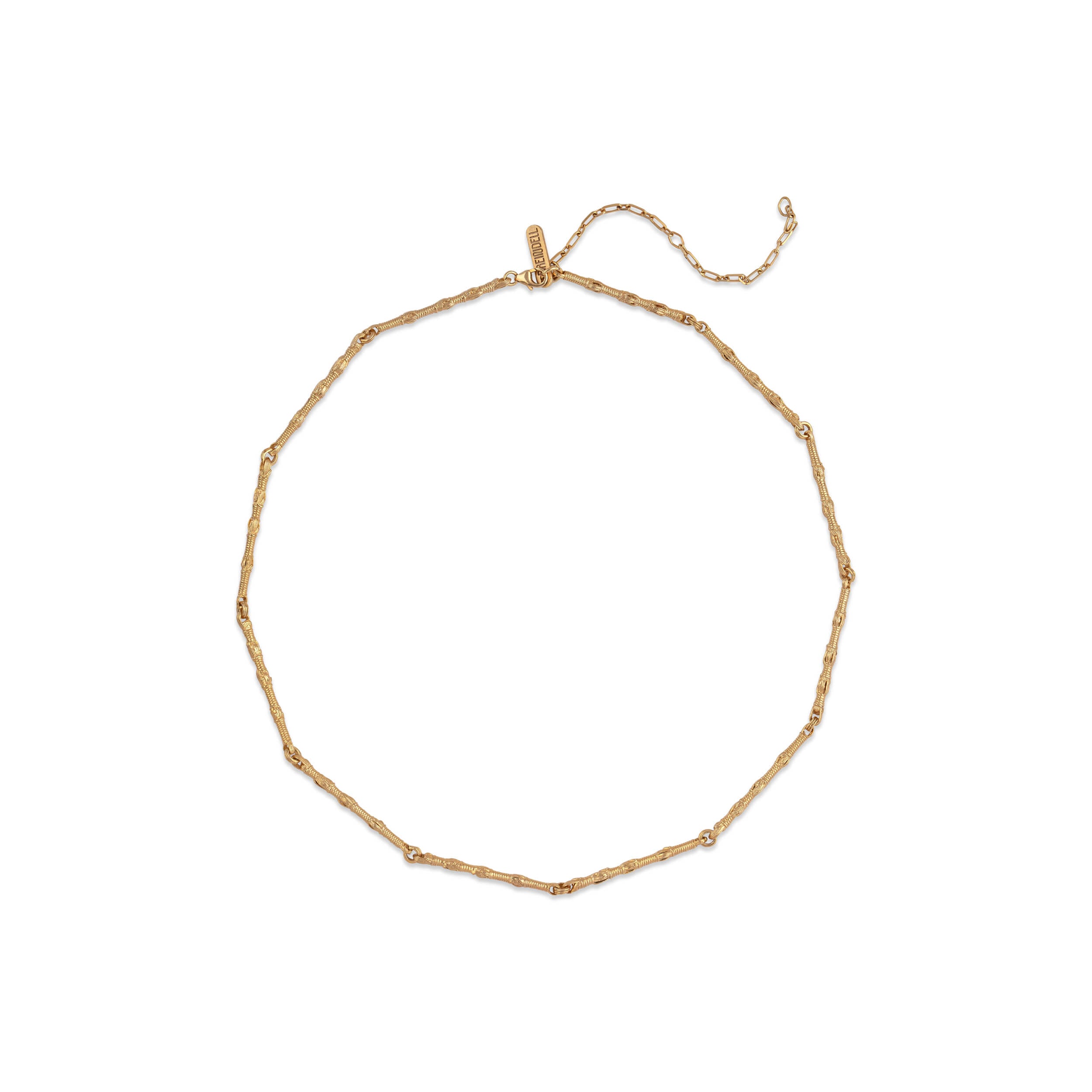 A minimalist flat lay of the Breindell Tzitzit I Necklace №1 in 14K gold. The composition emphasizes the high-lustre finish and architectural symmetry of the integrated knot, presented with a clean, structural shadow on a stark white background.