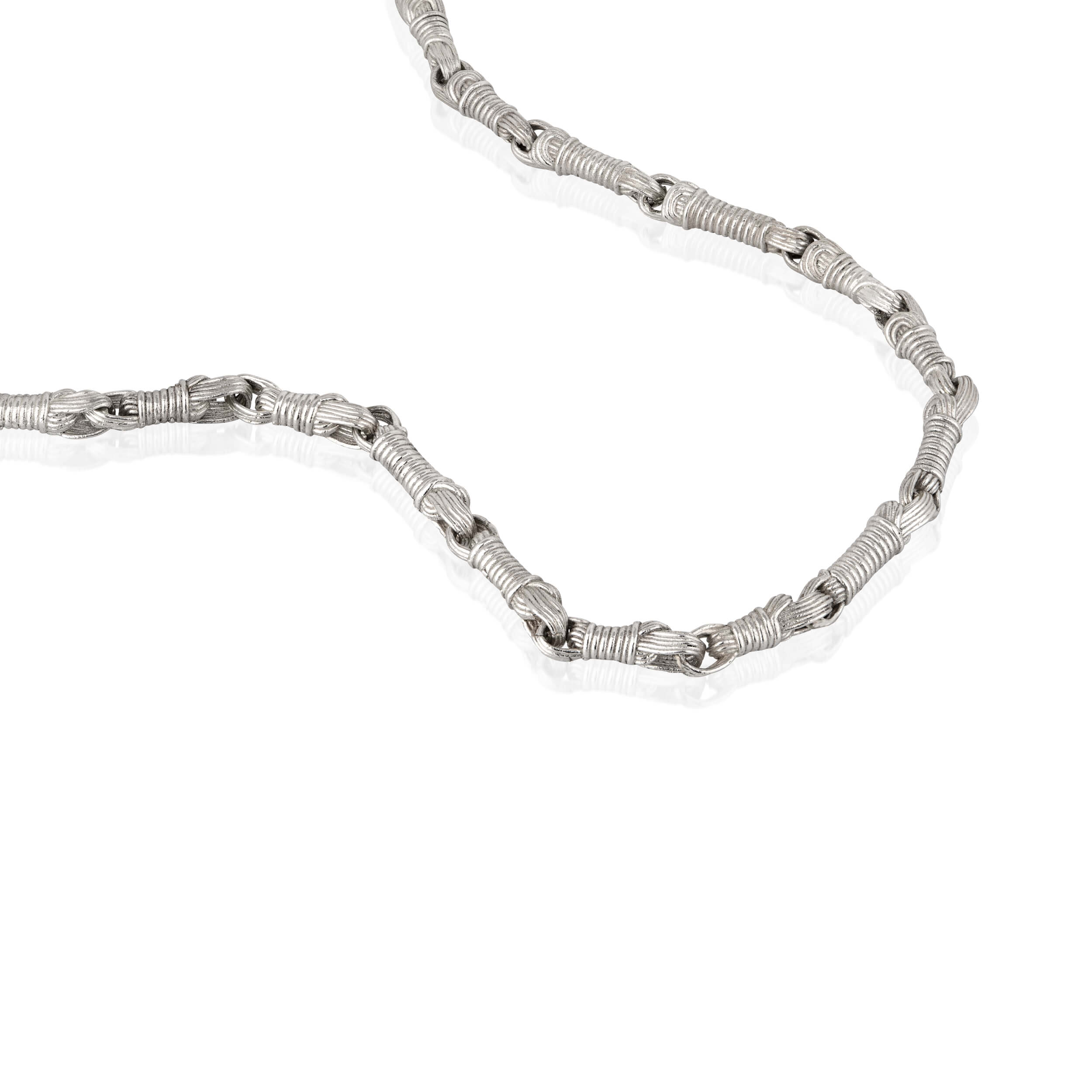 Macro detail of the Breindell Tzitzit I Necklace №2 in 925 sterling silver. The image highlights the refined architectural geometry and immaculate polished finish of the integrated knot, emphasizing a modernist and structural approach to luxury design.