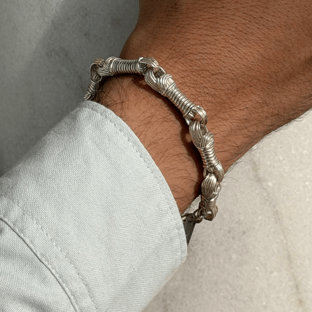 Male model wearing a sterling silver Tzitzit bracelet №3 paired with a blue shirt.